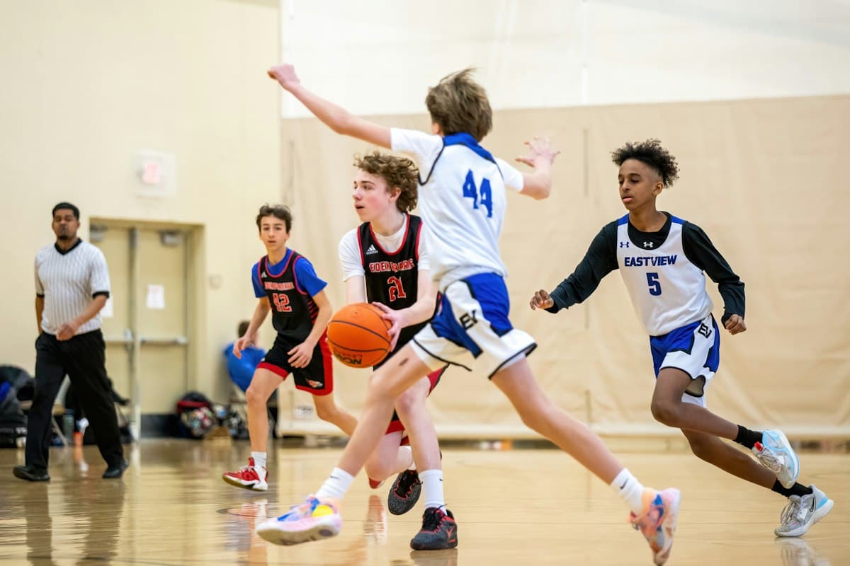 Teenagers playing basketball in a sports hall